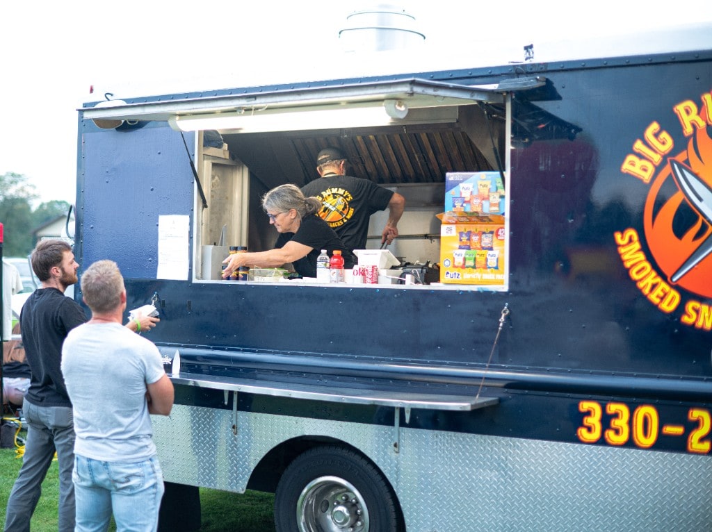 Customers ordering smoked snacks from the Big Rummy's food truck at Sparks of Giving