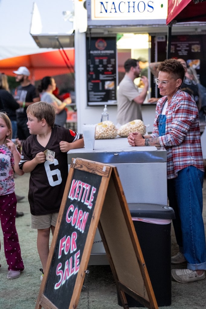 A child purchasing kettle corn from a vendor at Sparks of Giving