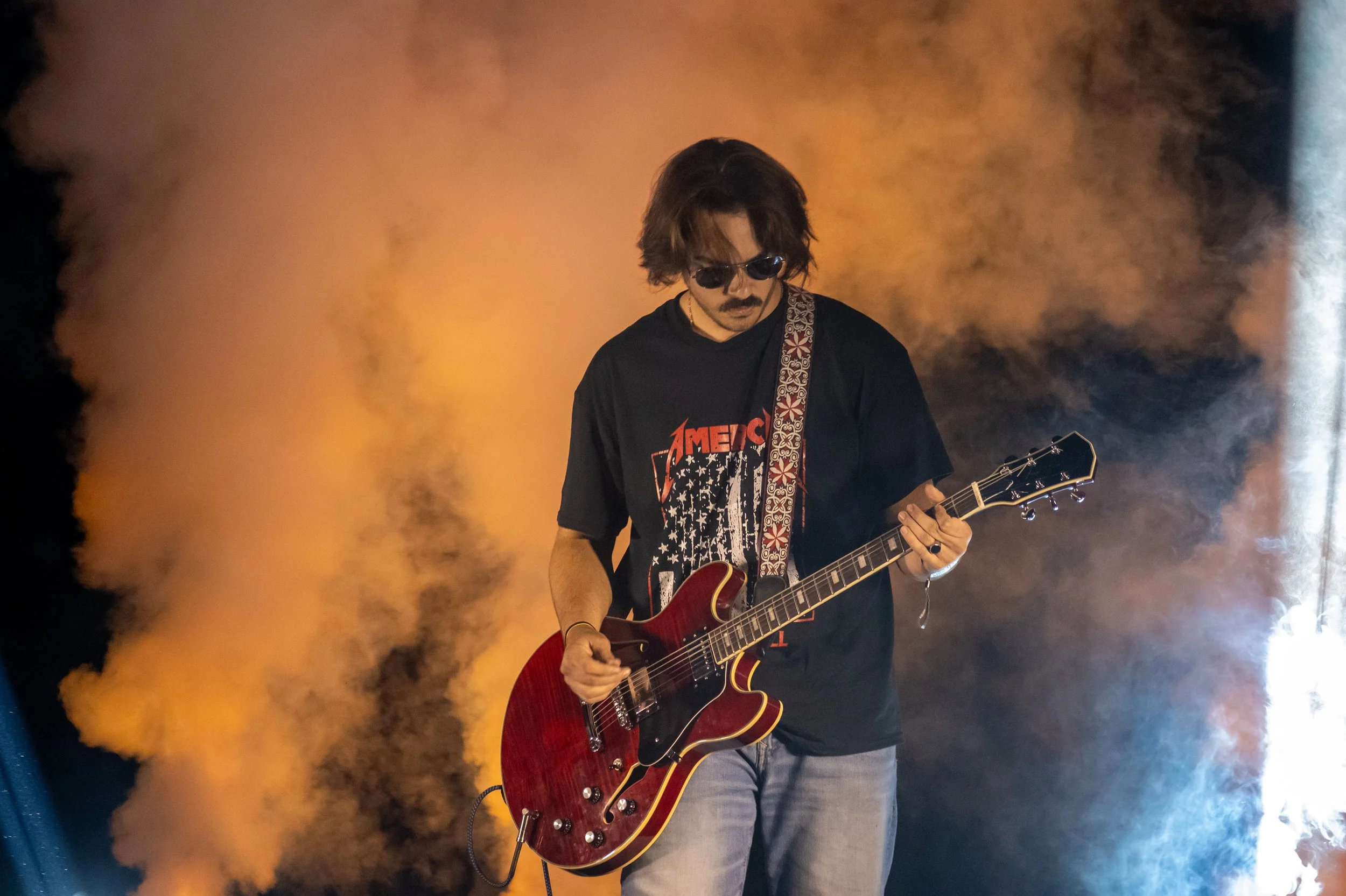 Guitarist performing on stage at Sparks of Giving
